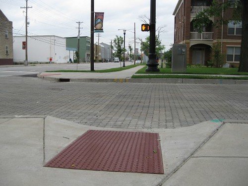 Sidewalk made accessible by having a curb cut and tactile paving